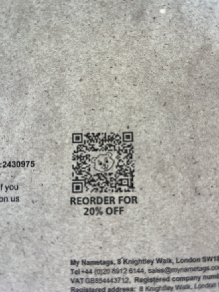 Close up of a printed flyer with a qr code on a textured surface visible text includes reorder for 20 off and business contact details