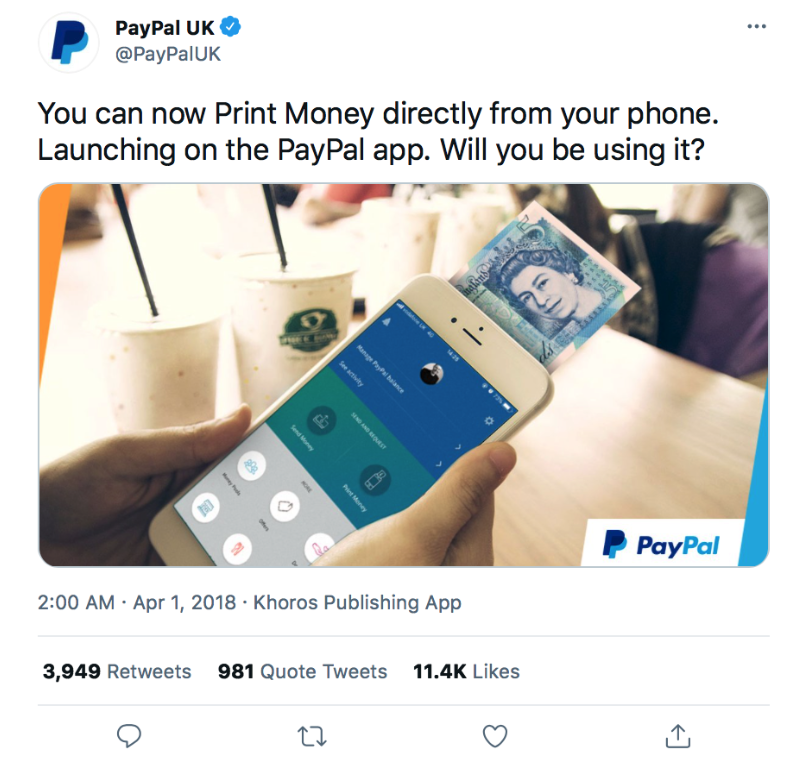 Person holds a smartphone showing the paypal app with a banknote tucked near the screen and a blurred cafe background paypal logo visible in the corner
