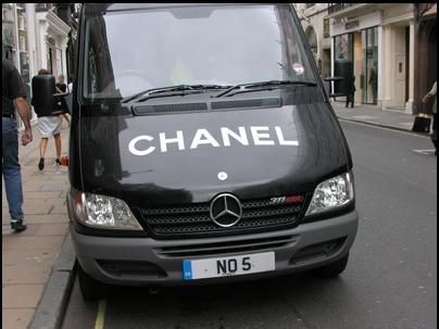 Img 5260 Black mercedes van parked on a city street with a large chanel logo across the hood and a european license plate reading no 5