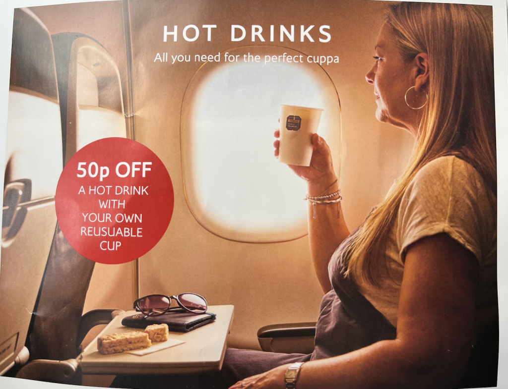 Woman on an airplane holding a cup of hot drink with a red promo circle offering 50p off