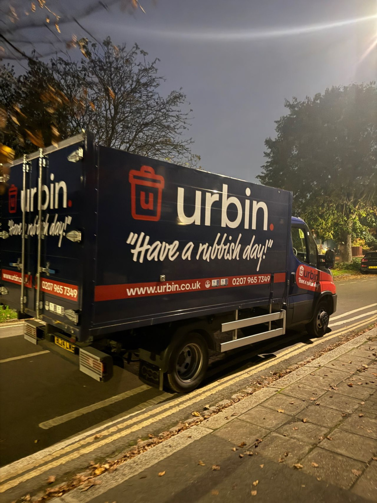 Blue urbin delivery truck parked on a street side panel reads have a rubbish day  with logo and website www Urbin Co Uk for waste removal services