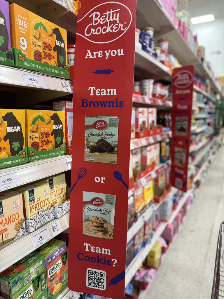 Img 2310 Promotional red vertical sign betty crocker are you team brownie or team cookies with brownie and cookie imagery in a grocery aisle