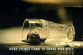 Glass tipped on its side with a small snail beside it caption reads good things come to those who wait