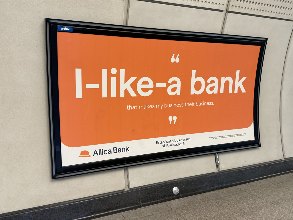 Img 5064 Orange advertising panel mounted on a concrete wall promoting allica bank with large white text and quotation marks