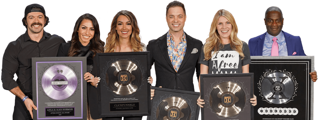 Six people smiling while posing with framed platinum and gold record plaques celebrating awards in a group photo