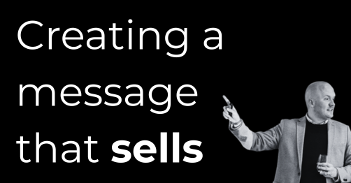 Bold white text reads creating a message that sells on a black background a man in a gray blazer points to the right while holding a glass