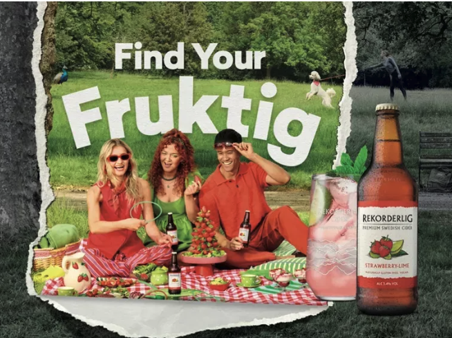 Three friends at a picnic outdoors fondling bottles of rekorderlig strawberry cider beside a torn paper collage that reads find your fruktig