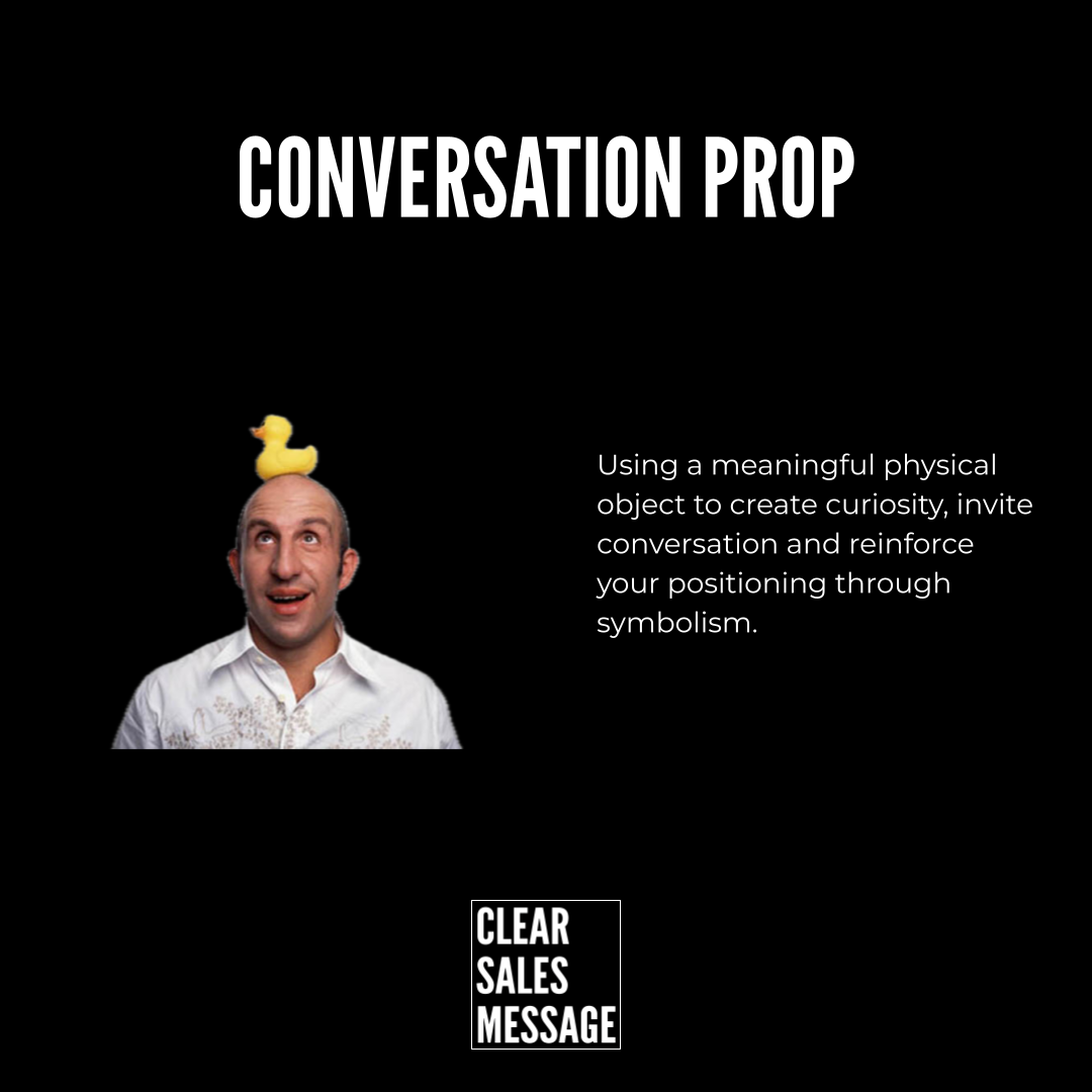 Slide with the title conversation prop on a black background a man with a yellow rubber duck on his head on the left and explanatory text about using objects to spark conversation on the right bottom shows a clear sales message logo