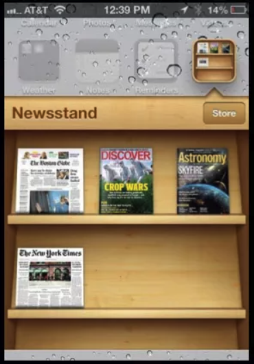 Screenshot 2026 08 14 at 140928 Iphone newsstand screen showing wooden shelves with magazine covers discover crop wars astronomy and the new york times on the lower shelf plus a store button at top right